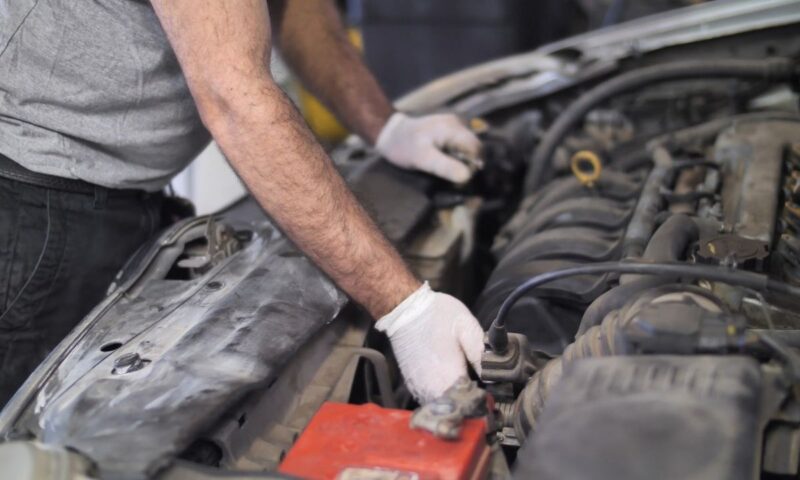 osoba gleda u otvorenu haubu automobila